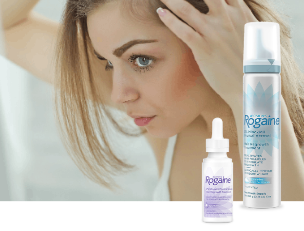 Woman checking her hair in the mirror with two bottles of Rogaine solution.