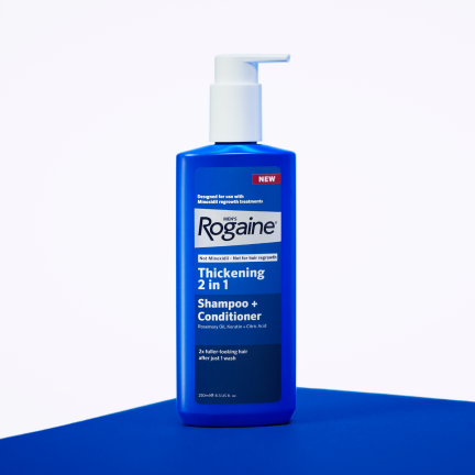 Blue bottle of men's ROGAINE 2-in-1 Shampoo + Conditioner on a white background