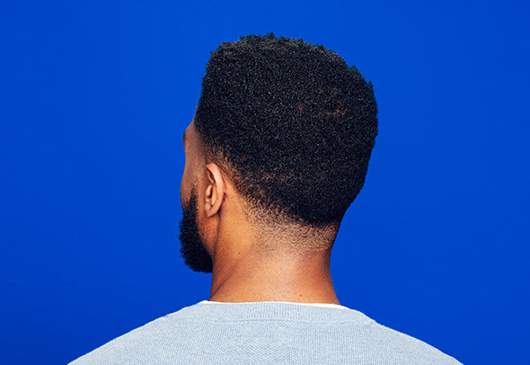 Back of a man’s head, on a blue background.