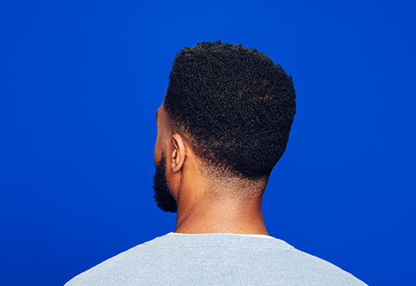 Back of a man’s head, on a blue background.